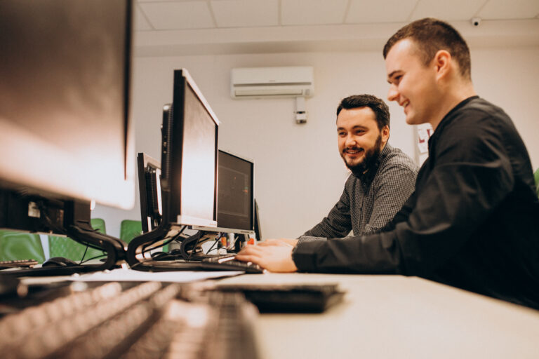 dois homens jovens que trabalhando como web designers usando computadores