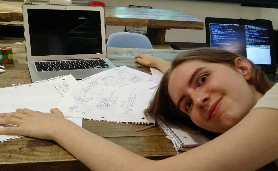A picture of Chelsea laying her head down on a bunch of paper.